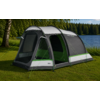 Gray tent with green and white stripes on grass beside a lake, open entrances with mesh, guy lines visible, birch tree at left, forest on opposite shore
