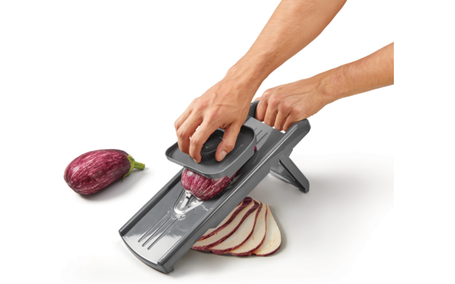 Hand schneidet eine Zwiebel mit einem Gemüseschneider