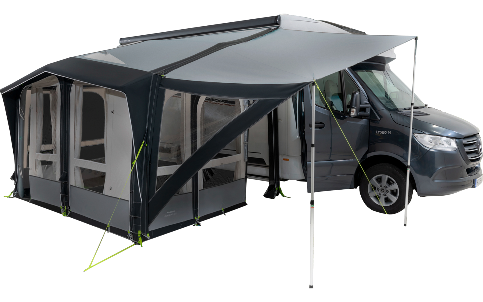 Camping-car avec auvent attaché sur une prairie à côté d'un lac