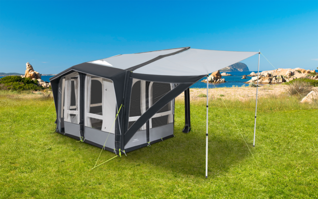 Faltbares graues Campingzelt mit großen Fenstern und Vordach auf grünem Gras in Küstennähe