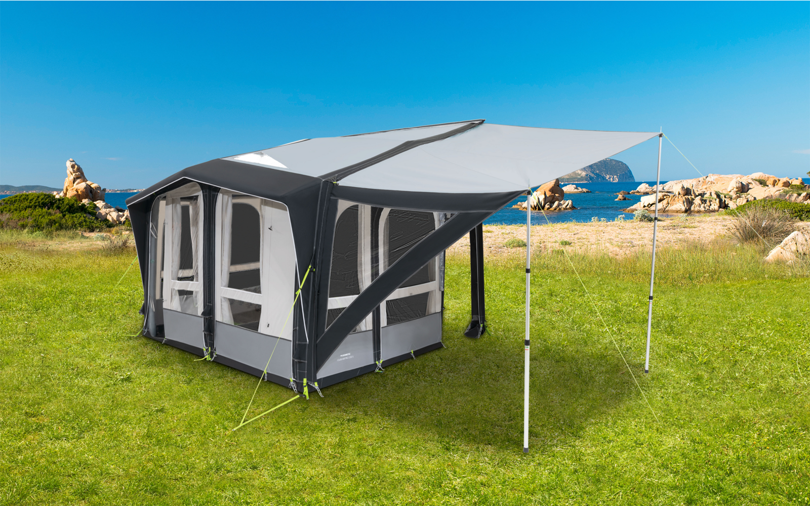 Faltbares graues Campingzelt mit großen Fenstern und Vordach auf grünem Gras in Küstennähe