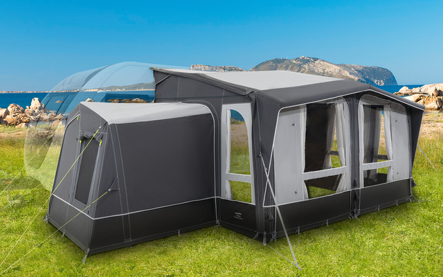 Grande tenda grigia per camper su erba verde con rocce sullo sfondo