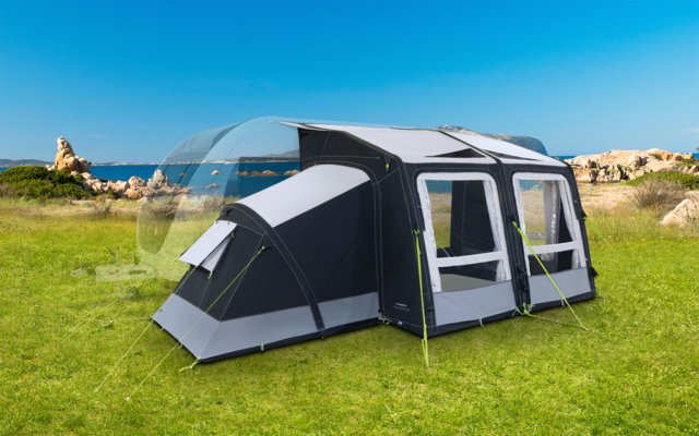 Large black and gray tent on a green meadow with blue sky and rocks in the background