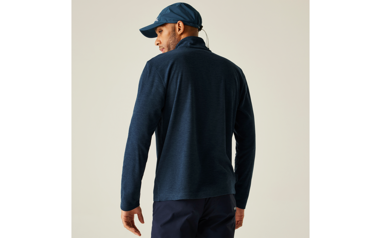 Mann von hinten mit dunkelblauer Jacke und blauer Mütze
