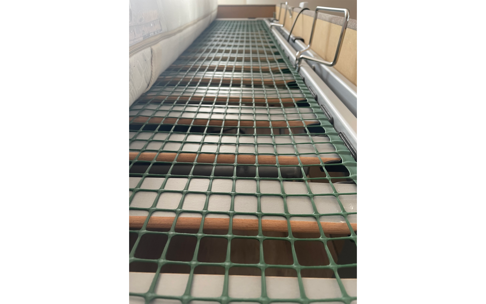 Nahaufnahme eines grünen Netzes über einer Holztreppe in einem Innenraum