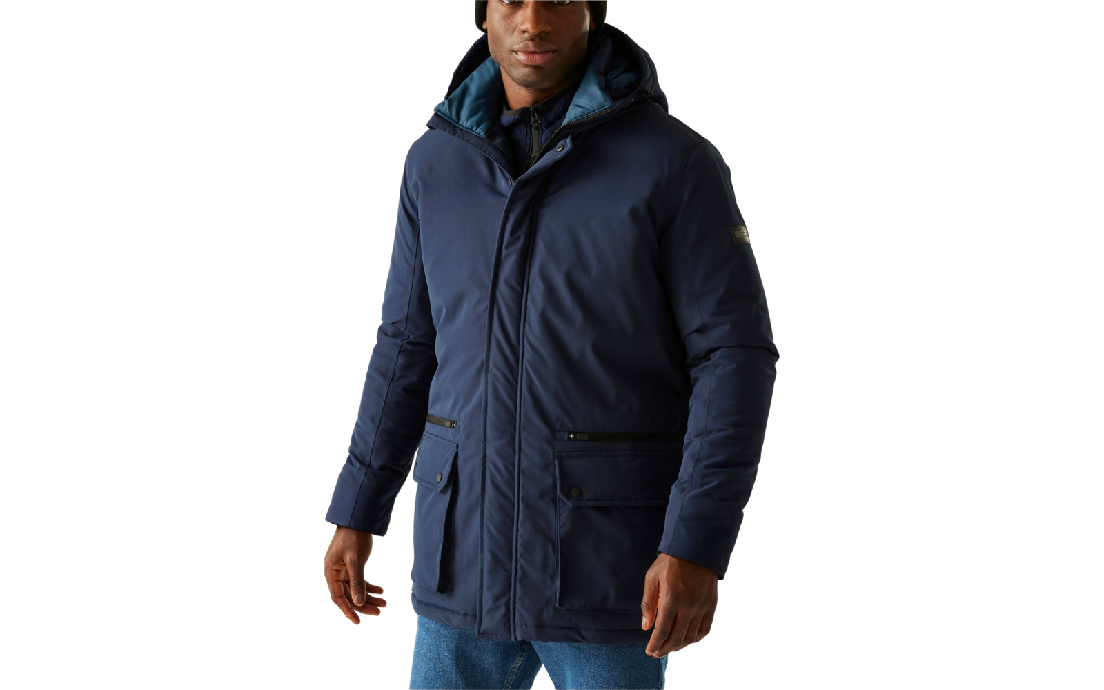 Mann trägt blaue Jacke und schwarze Mütze vor hellem Hintergrund