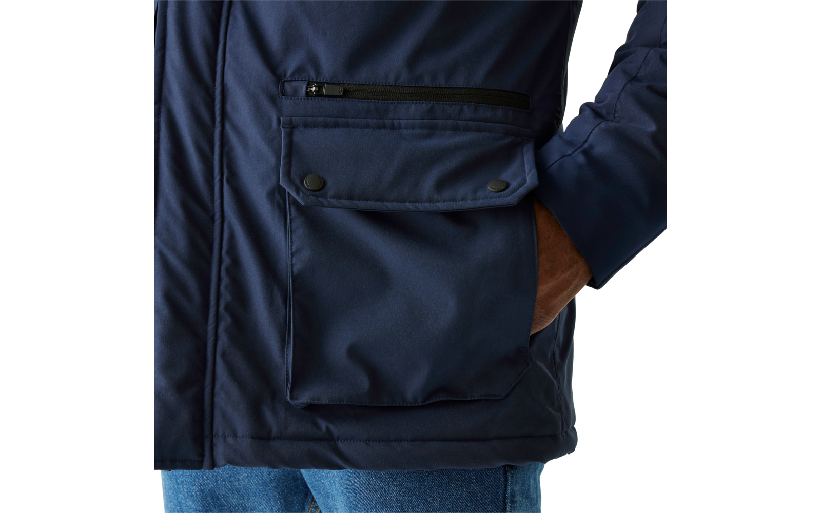 Person trägt eine dunkle Jacke mit aufgesetzter Tasche und hat eine Hand in der Hosentasche