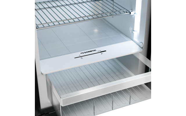 Weißer Innenraum mit Metall-Gitterregal oben, weiße Ablage mit Schriftzug "DOMETIC", halb geöffnete transparente Schublade mit Rippen, vertikale LED-Leiste an der rechten Seite