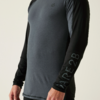 Oberkörper einer Person in grauem Langarm-Sportshirt mit schwarzen Ärmeln, Aufdruck "RARE2B" am Unterarm, kleines Logo auf der Brust, heller Hintergrund, sichtbare Hände