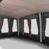 Interieur met stoffen plafond, meerdere rechthoekige ramen met vastgeknoopte gordijnen, verticale steunpilaren en donkere vloer