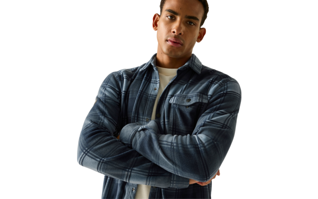 Man met gekruiste armen, blauw geruit overhemd over wit T-shirt, bovenlichaam zichtbaar, kort donker haar