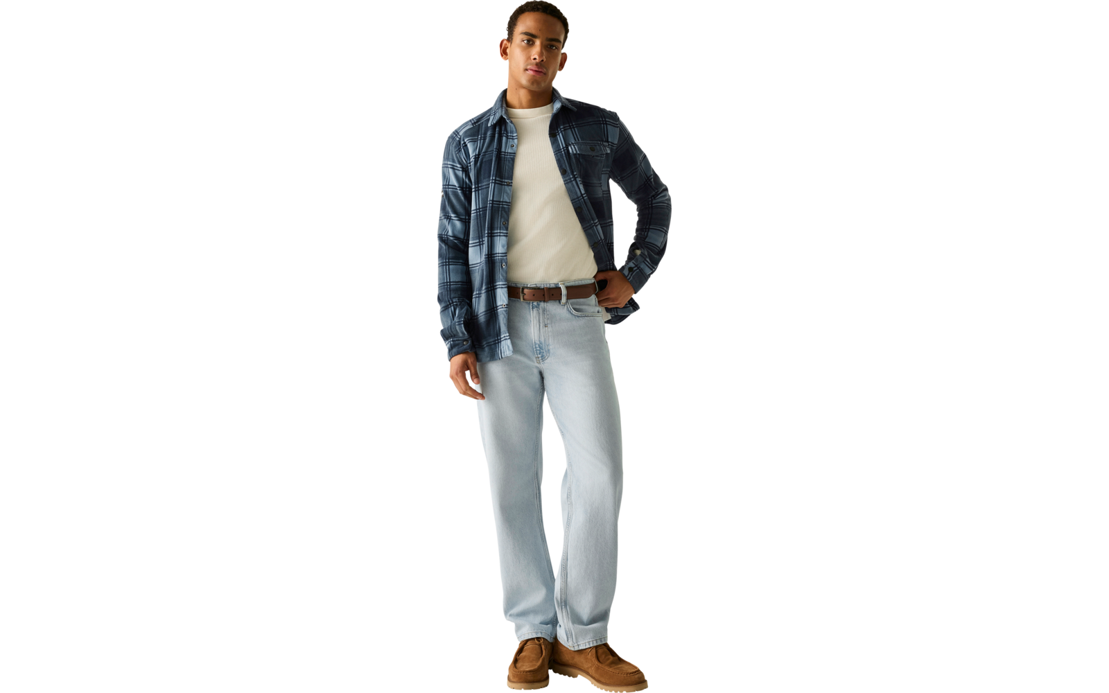 Staande persoon met donkerblauw geruit overshirt over een wit T‑shirt, lichtblauwe spijkerbroek, bruine riem, bruine veterschoenen, horloge om linkerpols
