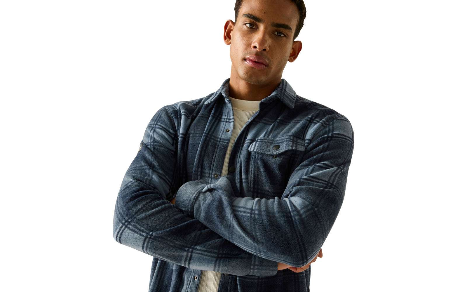 Man met gekruiste armen, blauw geruit overhemd over wit T-shirt, bovenlichaam zichtbaar, kort donker haar