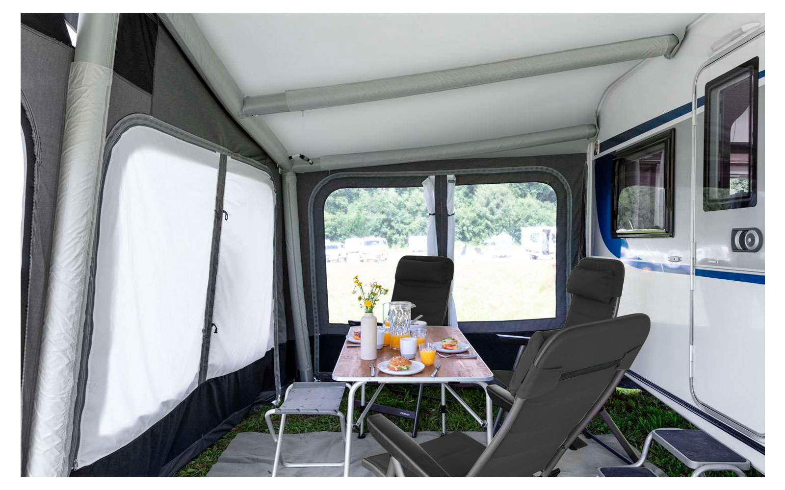 Interior of a camper with table, chairs, and door view