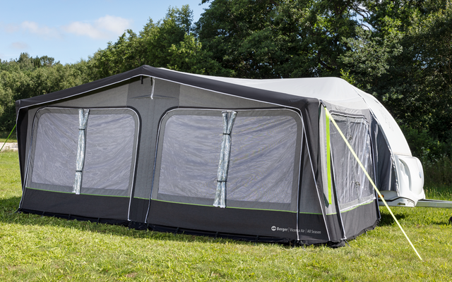 Large gray caravan awning with multiple windows, attached to a caravan on a grassy area with trees in the background
