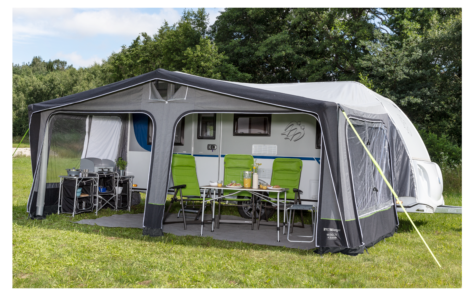 Large white motorhome with attached awning on a green lawn, cloudy sky