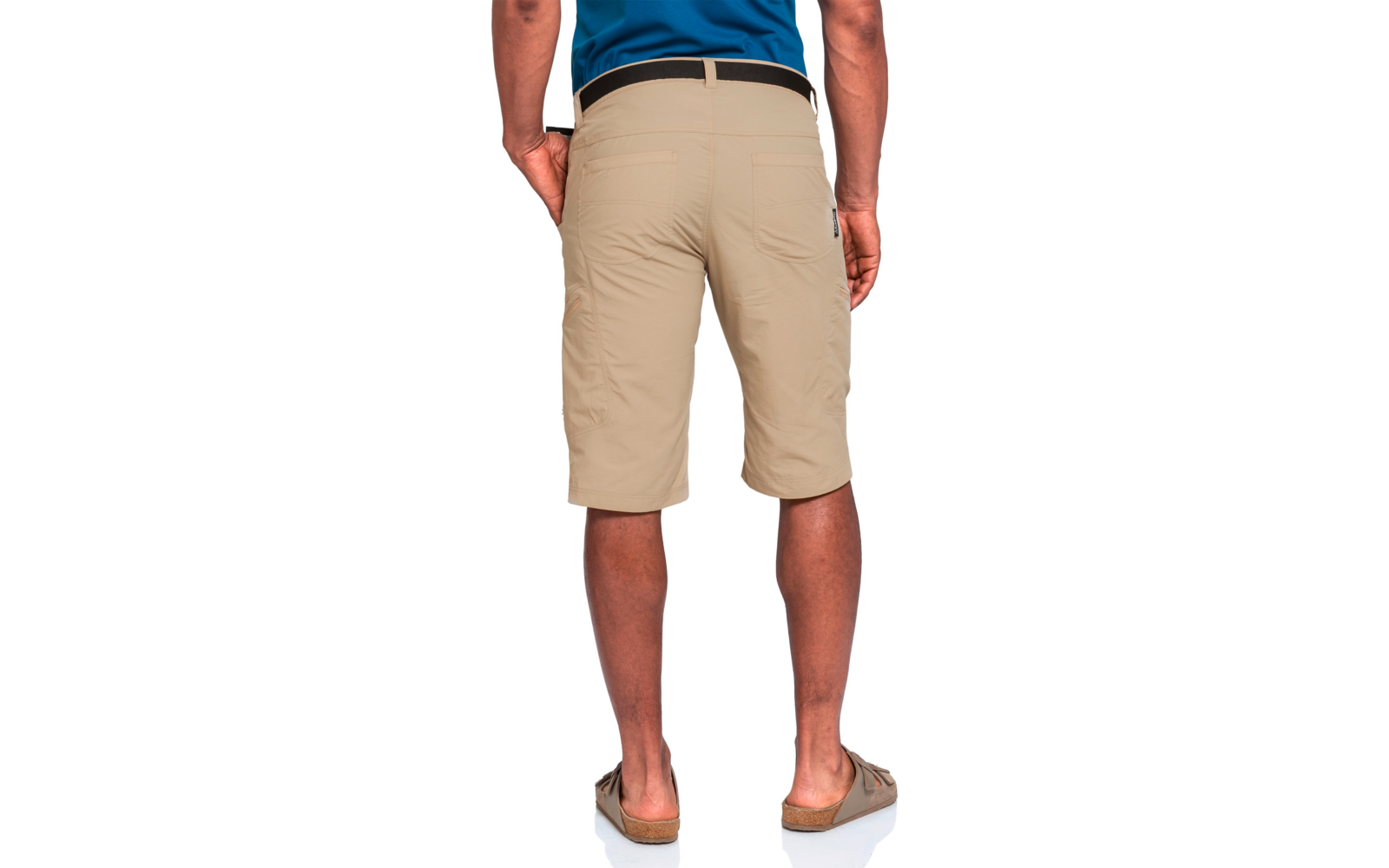 Rückenansicht einer Person in beige knielangen Shorts, blauem Oberteil, schwarzem Gürtel und braunen Sandalen; Hände seitlich, Beine sichtbar