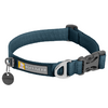 Collier pour chien en nylon bleu-vert avec fermeture à clip noire en plastique, deux anneaux métalliques, pendentif rond noir et étiquette noire portant le texte 'RUFFWEAR' et un logo jaune et blanc