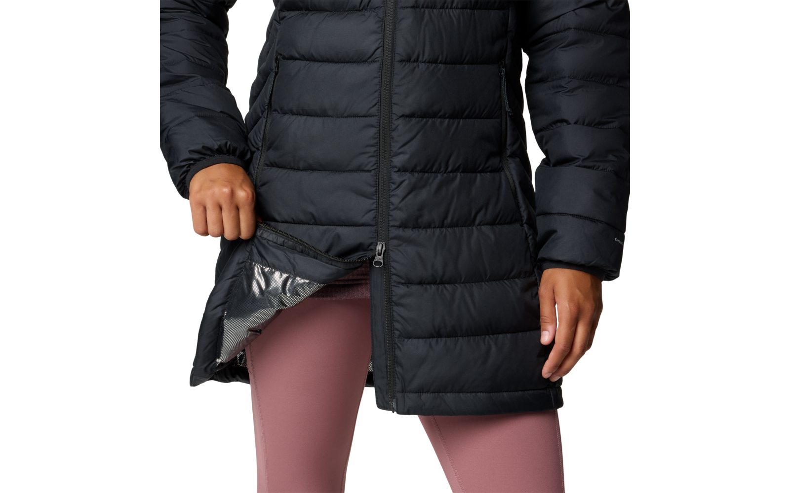 Gedeeltelijke weergave van een persoon in een zwarte doorgestikte lange jas; linkerhand houdt de zoom open, glanzende voering zichtbaar; benen in roze leggings