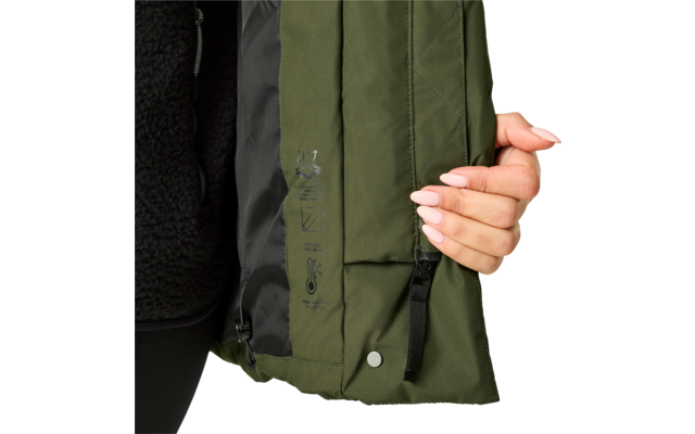 Hand mit hellrosa lackierten Fingernägeln hält den Saum einer olivgrünen Jacke; sichtbares schwarzes Innenfutter, Reißverschluss, Druckknopf, schwarze Zugschlaufe und bedruckte Symbole auf dem Stoff