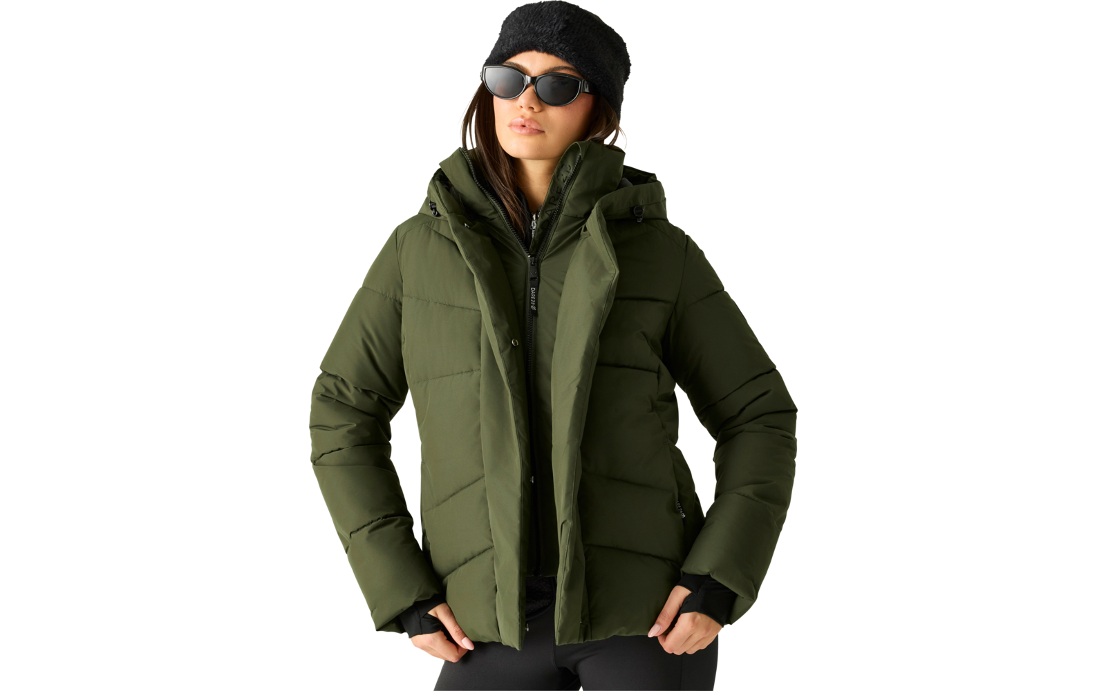 Person mit schwarzer Mütze und Sonnenbrille, olivgrüne gesteppte Jacke, Hände in den Taschen, frontal vom Oberkörper abgebildet