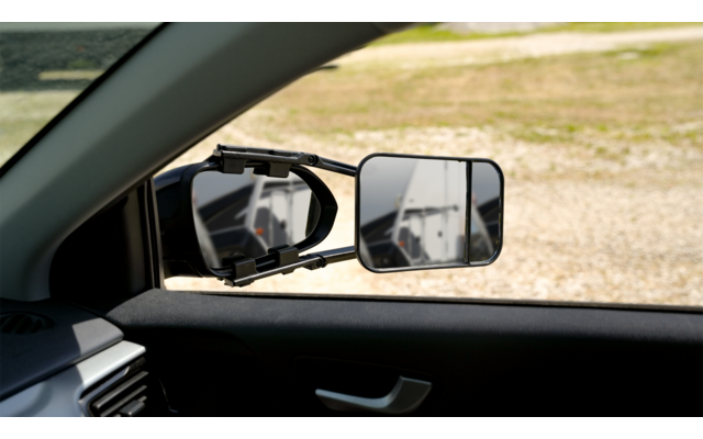 Blick durch das geöffnete Autofenster auf den Außenspiegel und den zusätzlichen rechten Spiegel, draußen ist eine Kiesfläche sichtbar