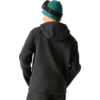 Person von hinten, dunkelgraue Kapuzen-Fleecejacke, türkisgrüne Strickmütze mit schwarzem Brillenband, dunkle Hose, heller Hintergrund