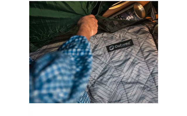 Hand berührt eine graue Daunendecke mit geometrischem Muster