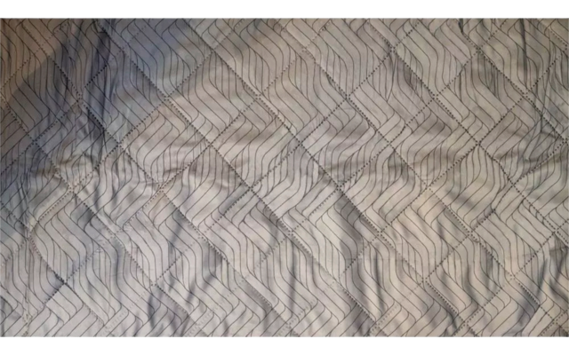 Braune und graue Stoffoberfläche mit gestepptem Rautenmuster