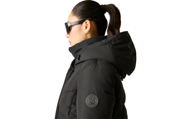 Person im Profil mit schwarzer Sonnenbrille, schwarzer gesteppter Jacke mit Kapuze, Pferdeschwanz und kleinem Ohrring