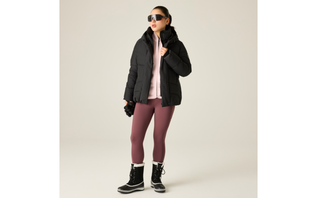 Person mit Sonnenbrille, schwarzer Steppjacke, rosa Kapuzenpullover, bordeauxfarbenen Leggings und schwarzen Winterstiefeln, hält Handschuhe, steht vor hellem Hintergrund