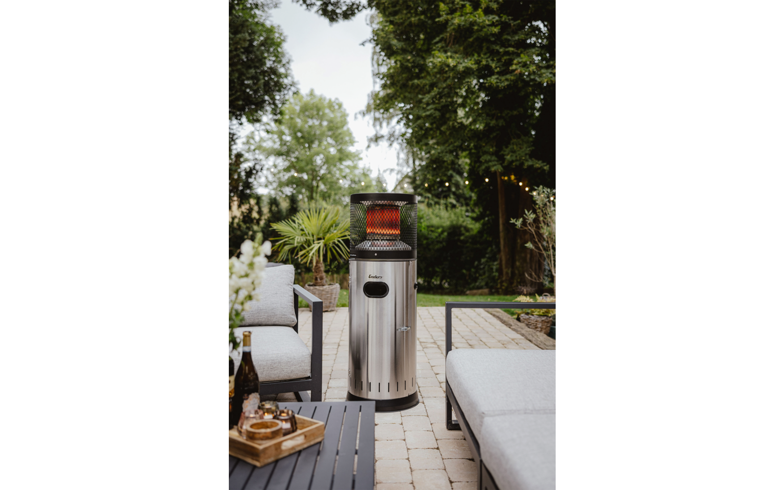 Moderner Mülleimer im Freien auf einer Terrasse mit Pflanzen und einer Holzbank
