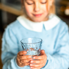 Kind hält ein Glas mit Wasser