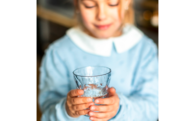 Kind hält ein Glas mit Wasser