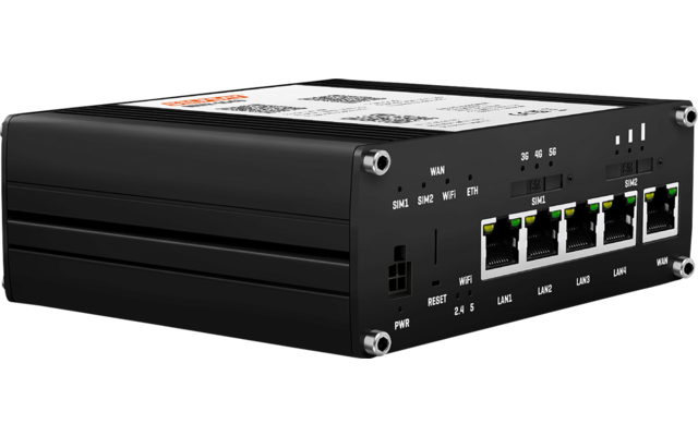 Schwarzes rechteckiges Metallgehäuse mit weißem Etikett oben, fünf Ethernet‑Anschlüsse mit grünen LED‑Anzeigen, mehrere Beschriftungen und kleine Tasten, zwei schmale Schlitze an der Seite, vier silberne Eckschrauben