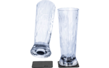 Two transparent textured glasses, one standing on a black coaster, one lying down