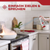 Hand sprayt brandblusser op brandende pan in moderne keuken