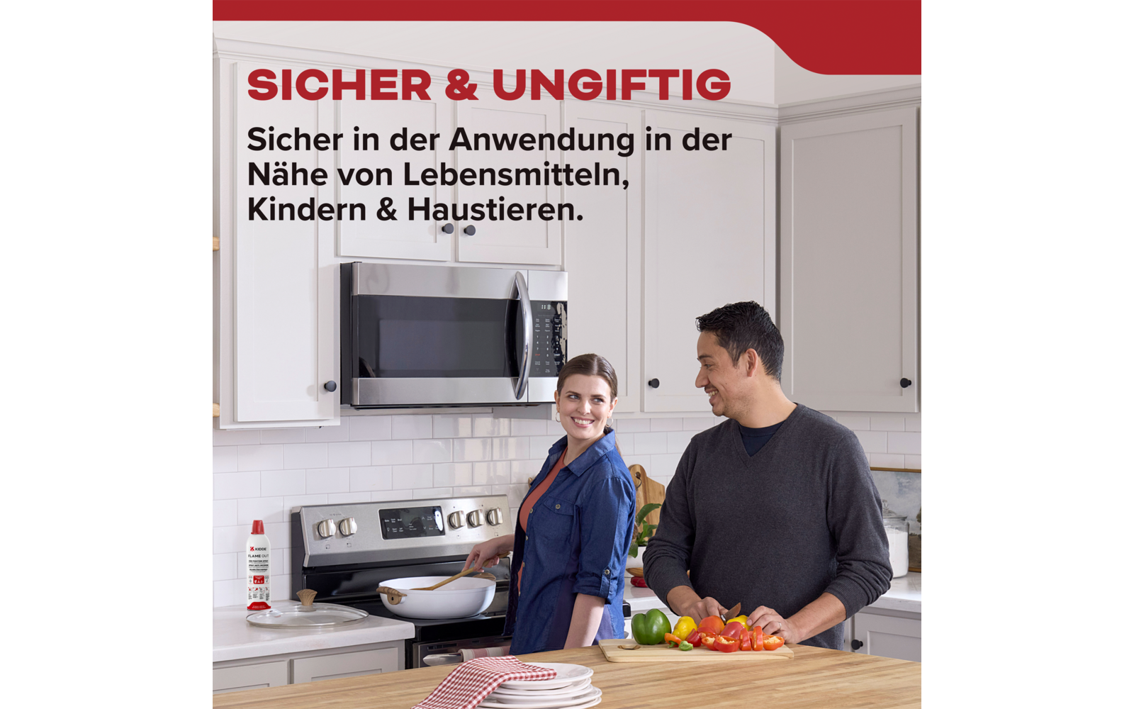 Man en vrouw in moderne keuken, man snijdt groenten, vrouw staat glimlachend bij het fornuis