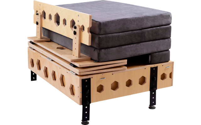 Mehrere gestapelte graue Polster auf einem hellbraunen Holzgestell mit sechseckigen Ausschnitten und schwarzen Metallbeinen