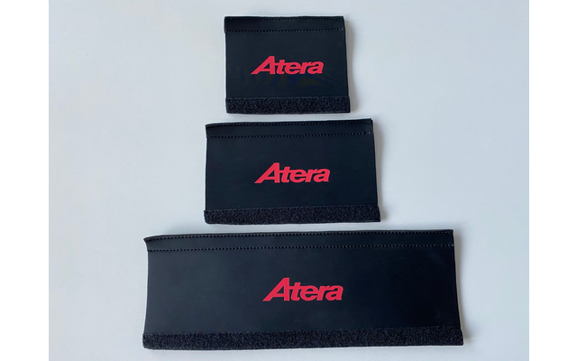 Drie zwarte rechthoekige stoffen banden met rood "Atera"-logo, verticaal gestapeld van klein naar groot op een lichte achtergrond