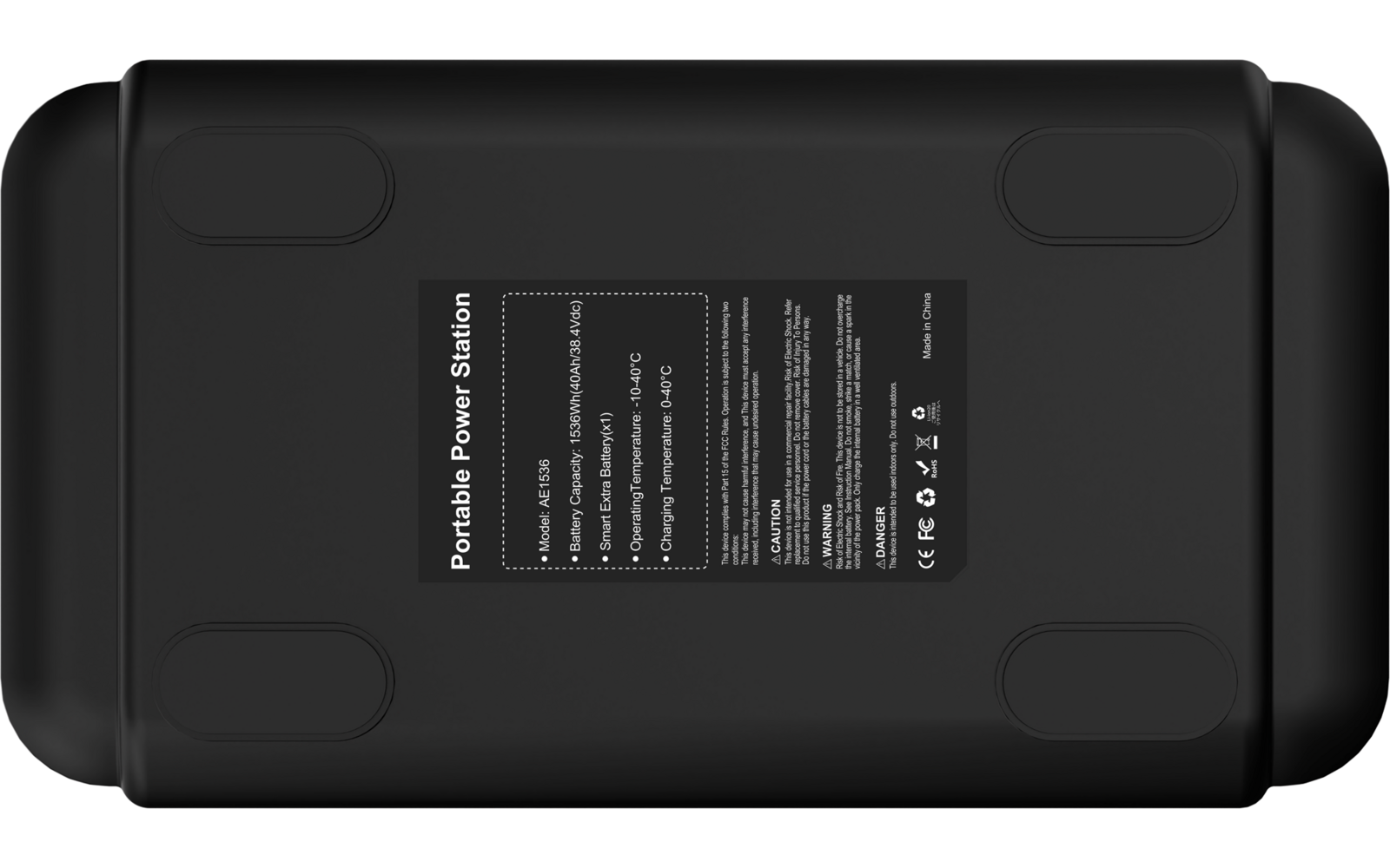 Unterseite eines schwarzen rechteckigen Geräts mit mittigem Etikett mit weißer Schrift und Symbolen und vier Gummifüßen an den Ecken