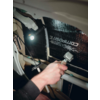 Hand hält einen Schraubenschlüssel und arbeitet an einem elektrischen Gerät