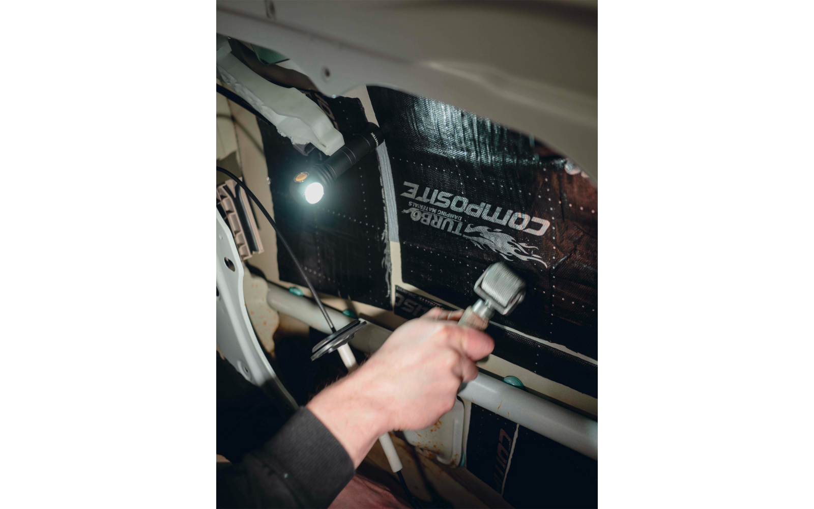 Hand hält einen Schraubenschlüssel und arbeitet an einem elektrischen Gerät