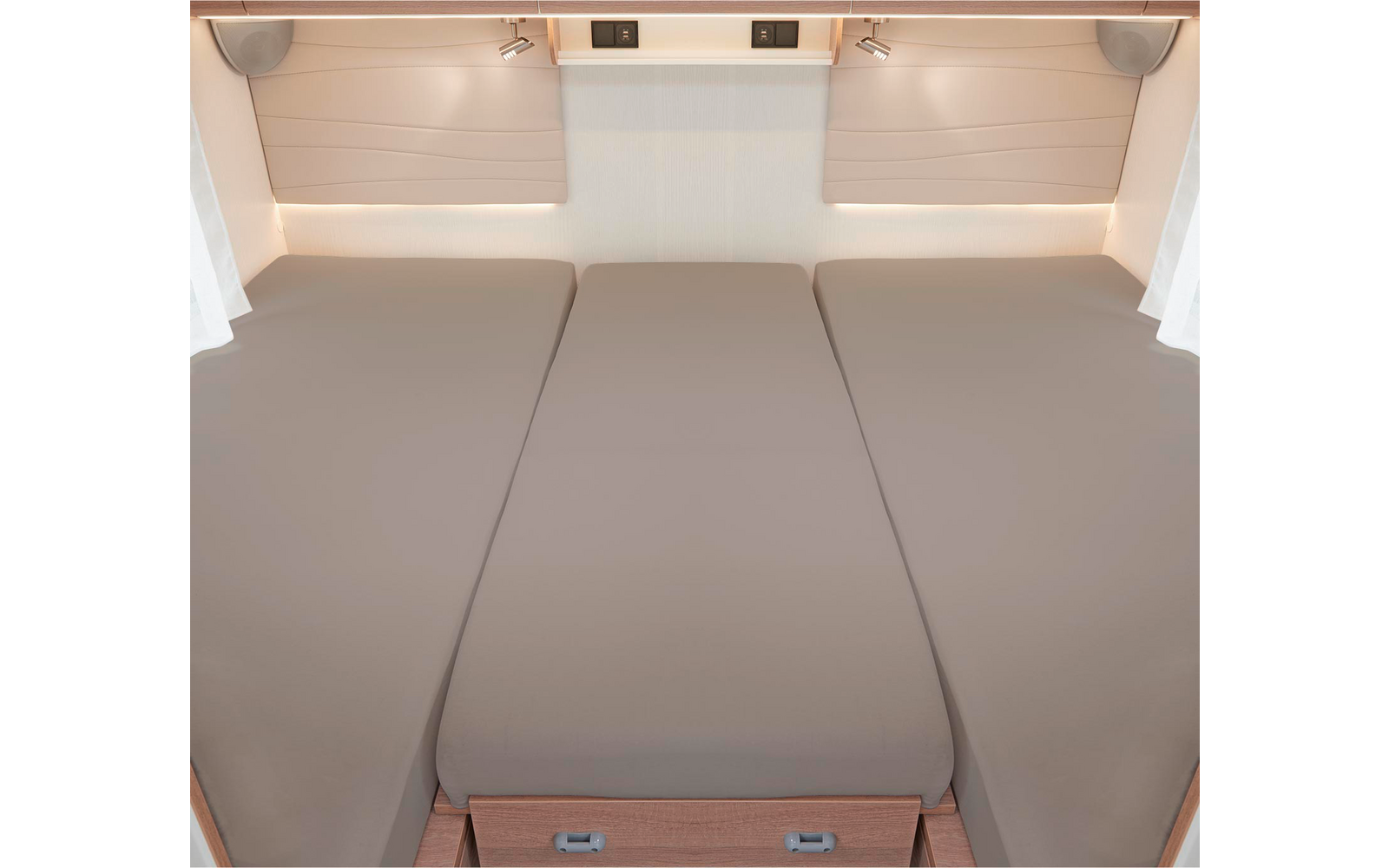 Trois lits côte à côte avec des matelas beiges dans un camping-car