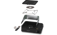 Portabler Gaskocher mit auseinandergefügten Teilen: Unterbau mit Brenner und Drehknopf, gebogener Metallwindschutz, quadratisches Drahtgitter, runder Brennerring, geriffelte Grillplatte und zwei kleine Metallteile an der Seite