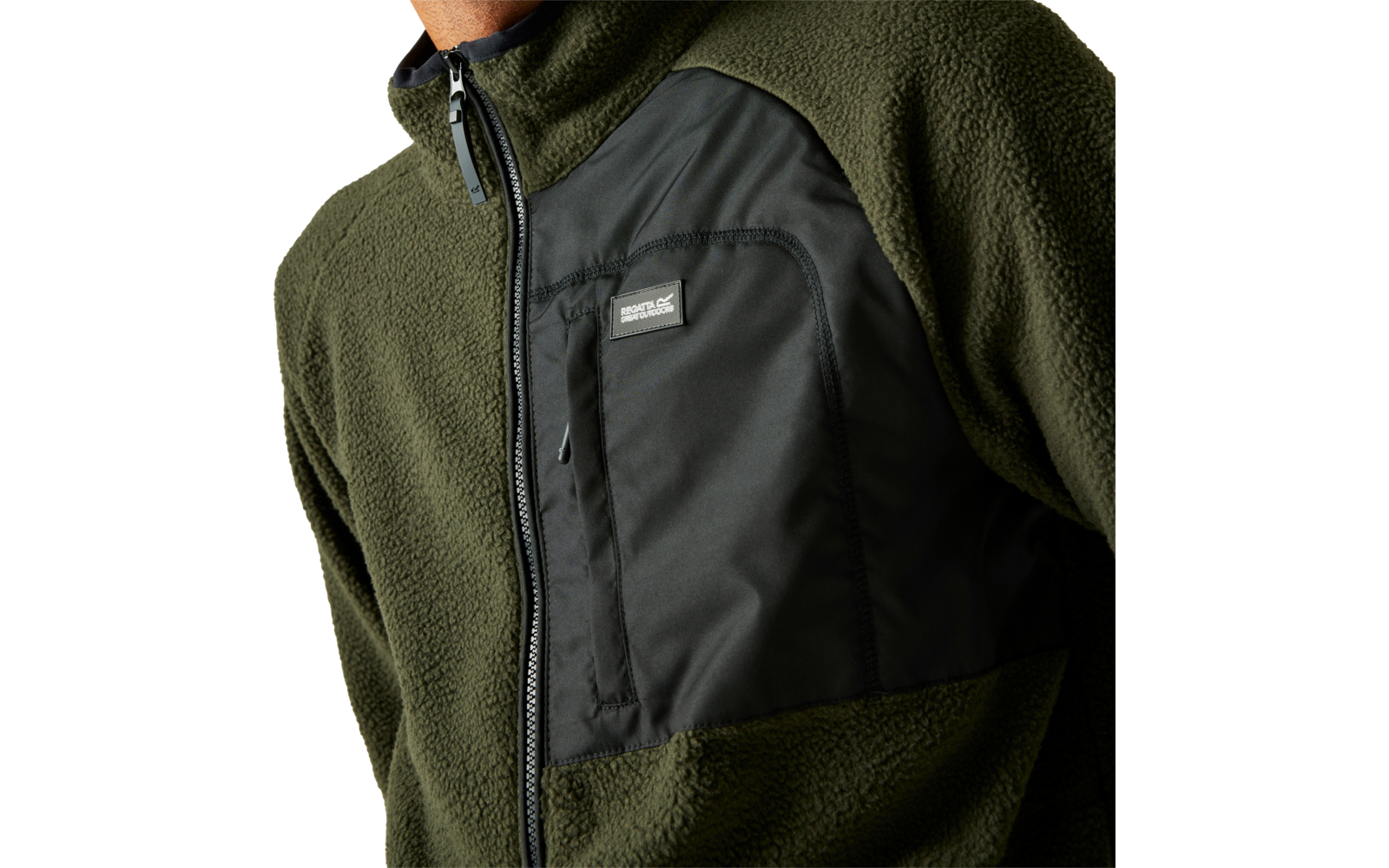 Nahaufnahme einer grünen Fleecejacke mit schwarzem Reißverschluss und Logo auf der Brust