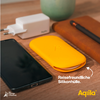 Smartphone, weißes Ladegerät, gelbe Silikonhülle und braune Ledertasche auf einem Holztisch