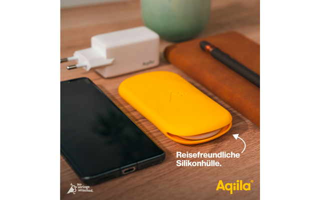 Smartphone, weißes Ladegerät, gelbe Silikonhülle und braune Ledertasche auf einem Holztisch
