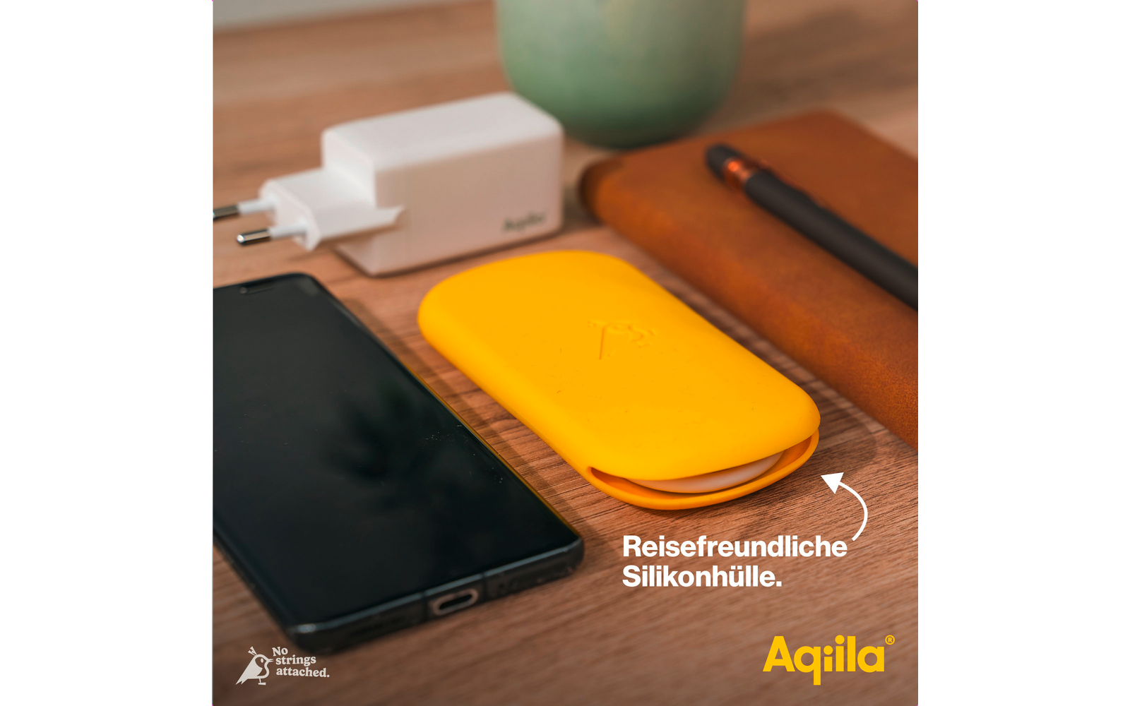 Smartphone, weißes Ladegerät, gelbe Silikonhülle und braune Ledertasche auf einem Holztisch