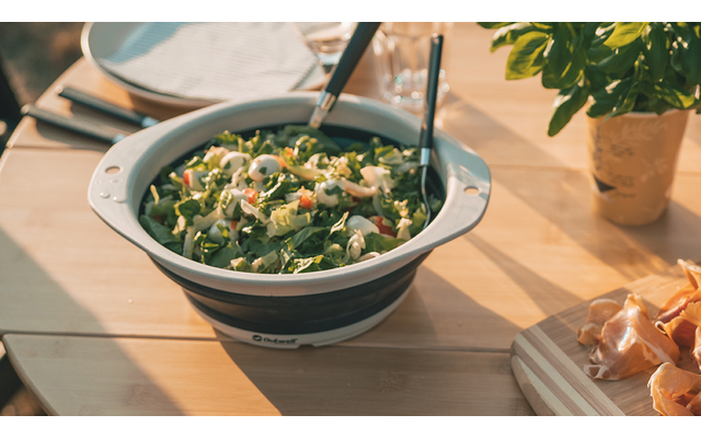 Bol de salade verte avec des couverts sur une table en bois